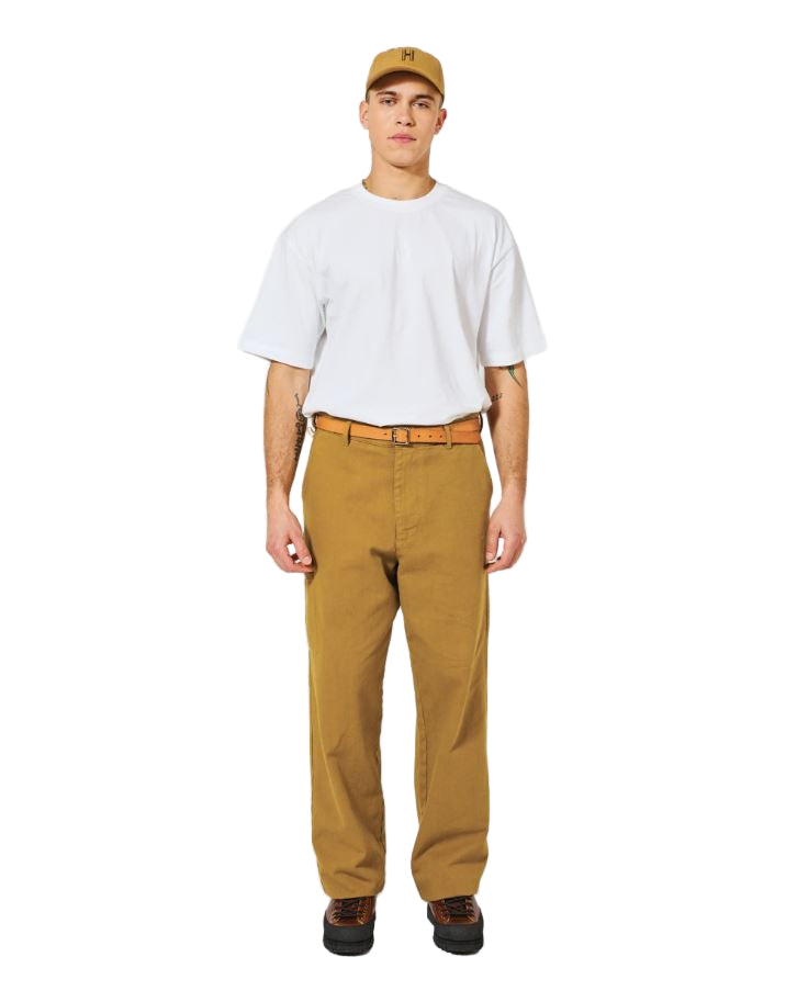 Person wearing a white t-shirt, brown pants, and a cap on a white background